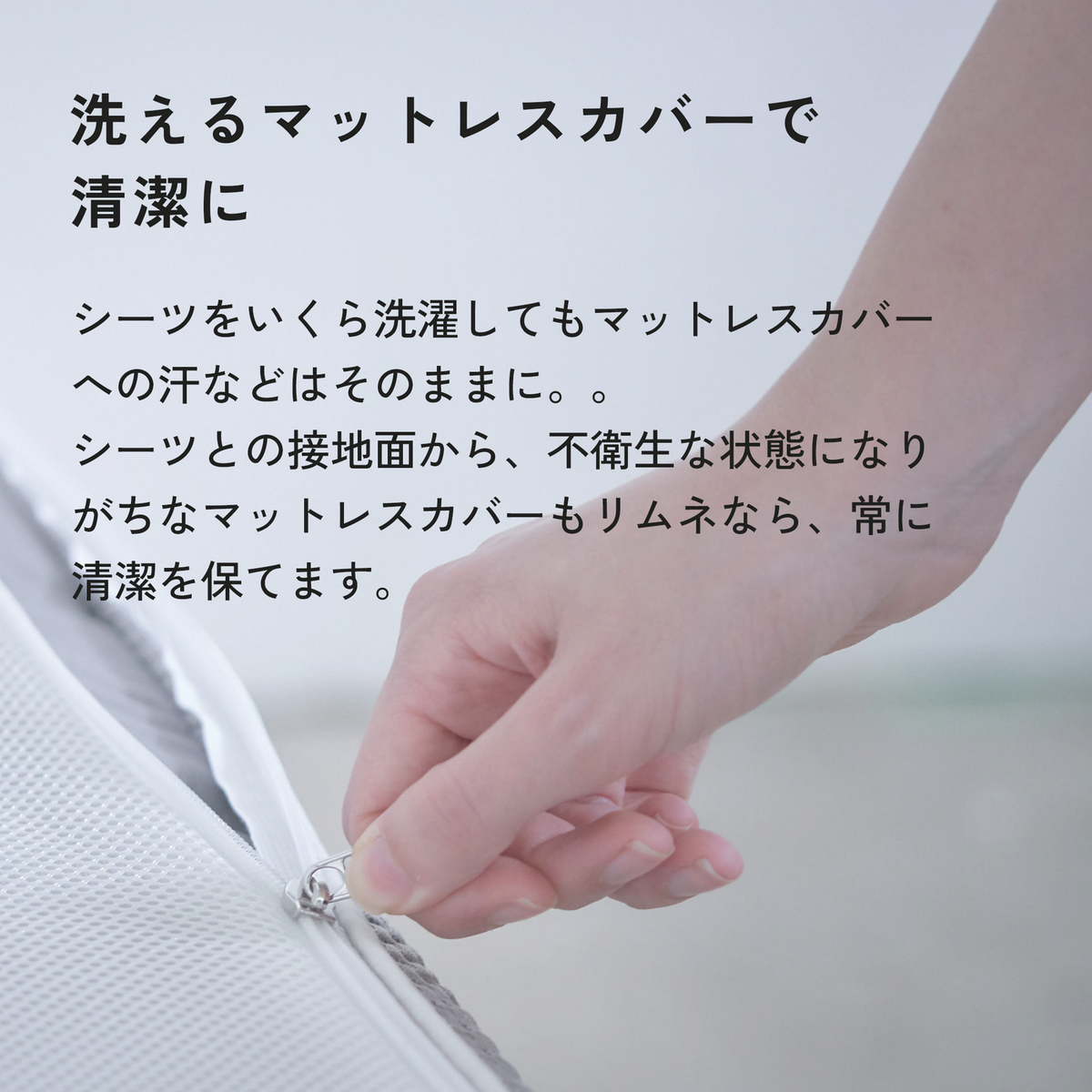 マットレスカバー側面のファスナーを開ける手元